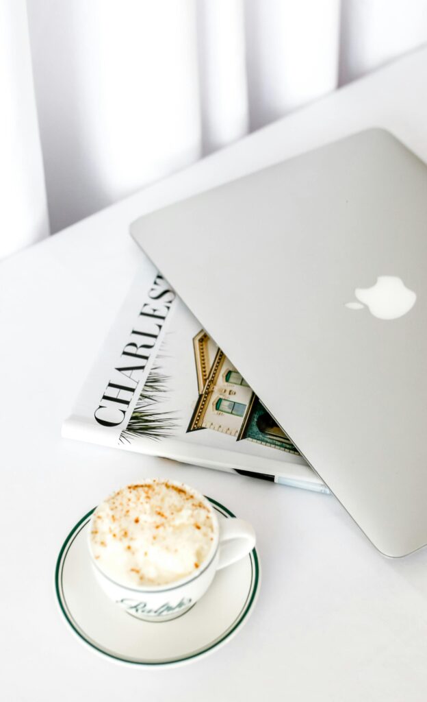 pexels-photo-28347063-28347063 A sleek laptop beside a cappuccino on a bright, modern workspace.